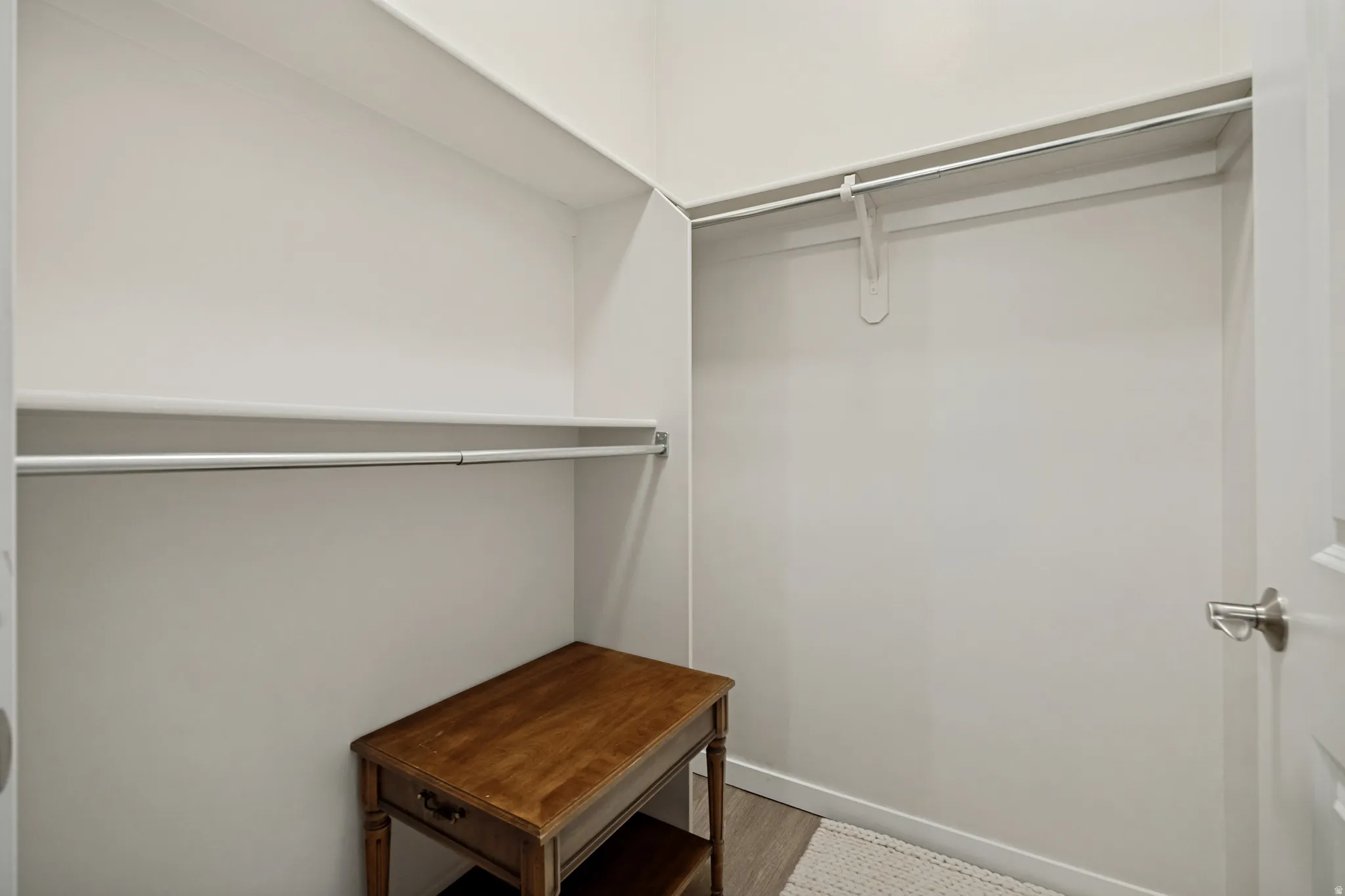 Built-in shelving, two hanging rods, and wood-finish flooring