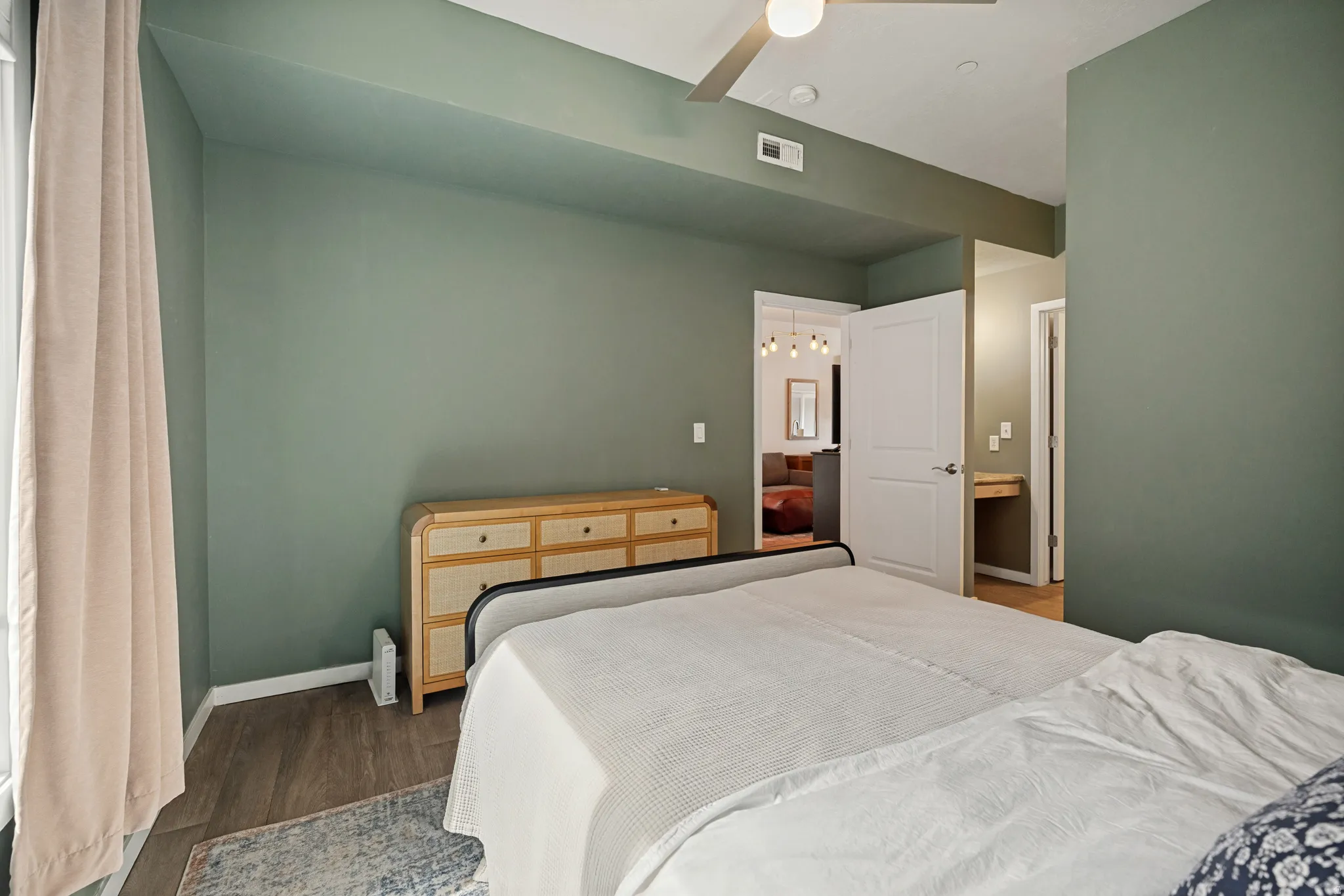 High ceilings, wood-finish flooring, and a ceiling fan with integrated lighting