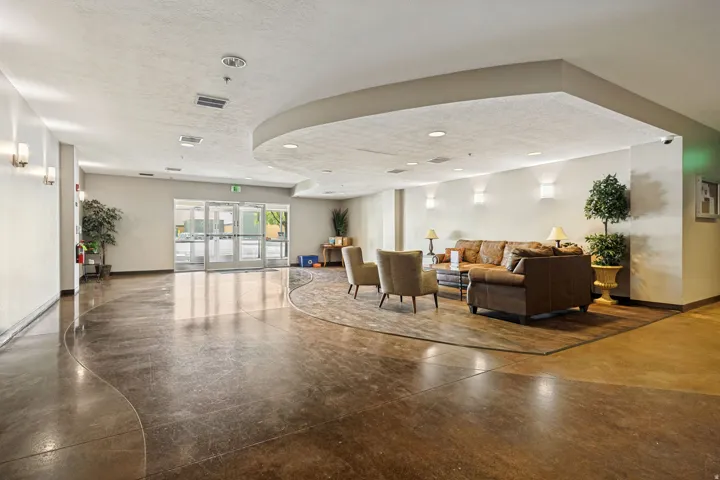 Expansive common area featuring a curved ceiling detail, recessed lighting, and glass entry doors