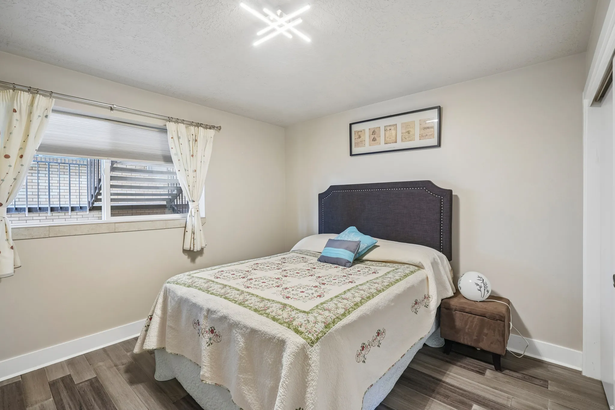Wood-finish flooring, neutral wall tones, and a modern ceiling light fixture
