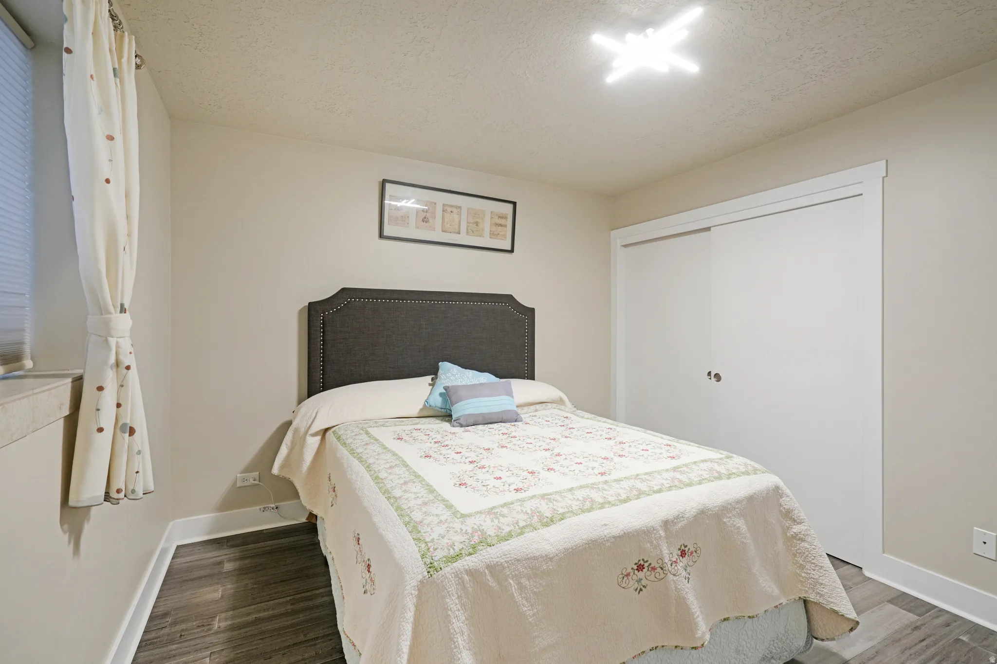 Wall-to-wall wood-finish flooring, sliding closet doors, window with blinds, and recessed lighting