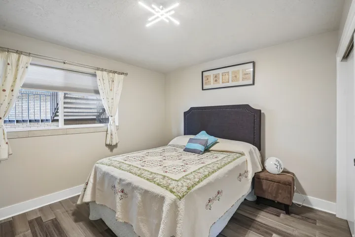 Wood-finish flooring, neutral wall tones, and a modern ceiling light fixture