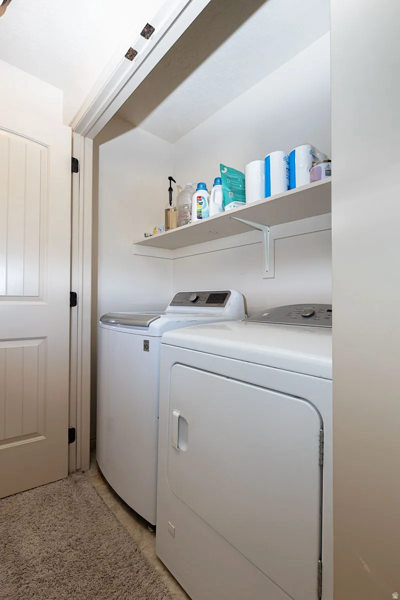Recessed laundry area featuring a built-in shelf and white interior door with black hardware
