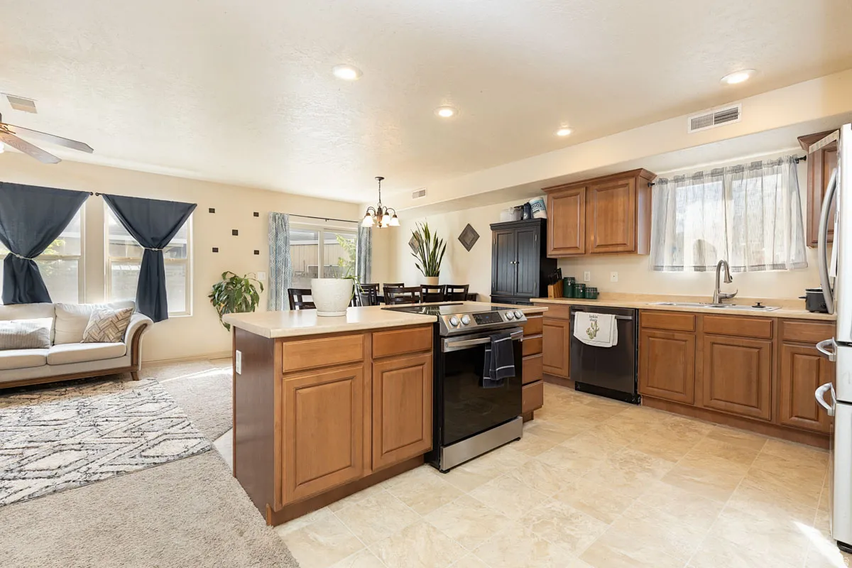 Kitchen featuring an island, wood-finish cabinetry, stainless steel appliances, and light-toned countertops