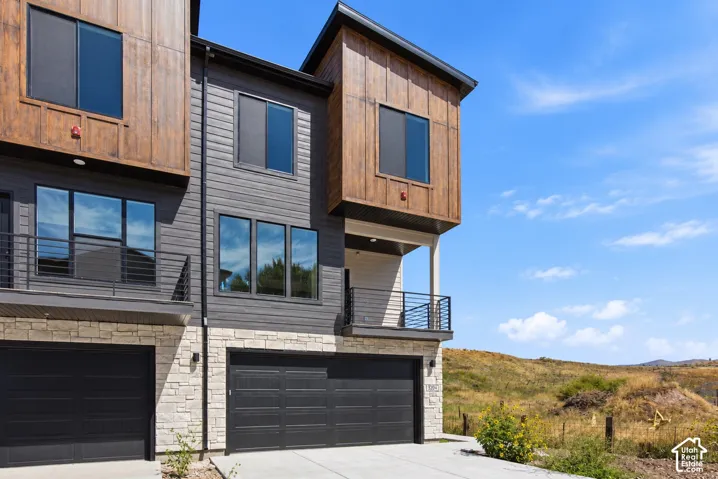 Multi-story exterior with mixed material facade, featuring wood paneling, horizontal siding, and stone veneer