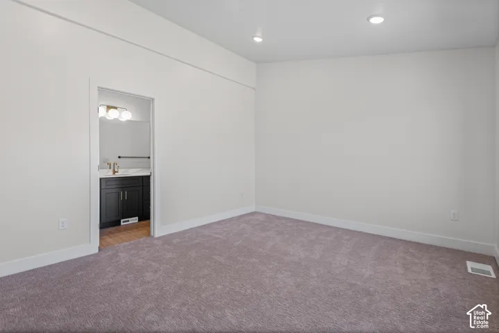 Recessed ceiling lighting, plush carpeting, bright white wall paint, and white trim