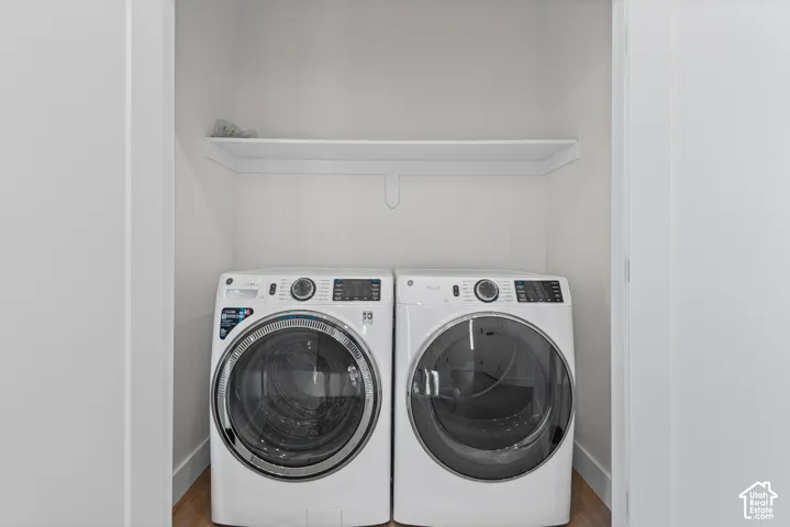 Laundry area with a built-in shelf and wood-finish flooring