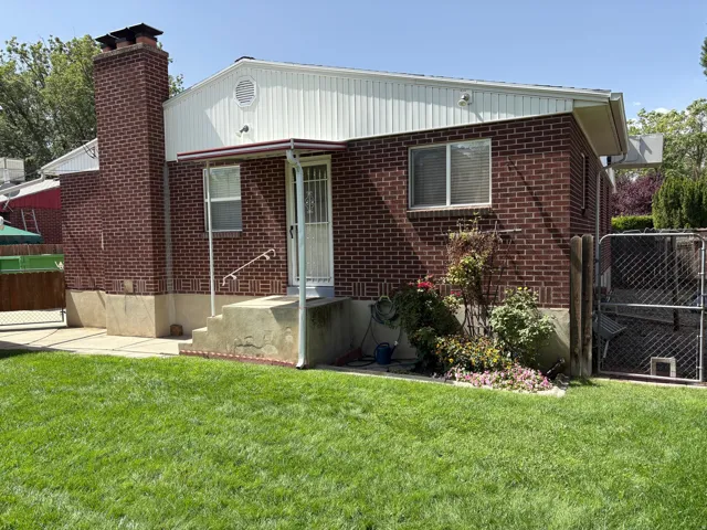 Brick exterior with white siding accents and a prominent brick chimney