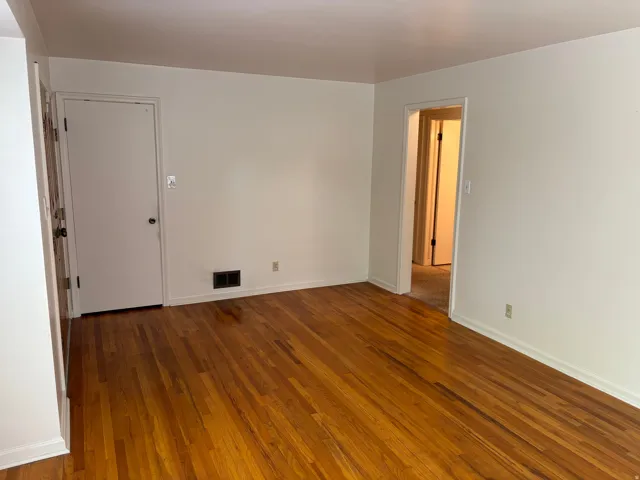Hardwood flooring throughout, white walls, and white trim