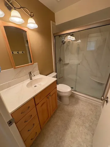Wood-finish vanity with an integrated sink and light-toned countertop