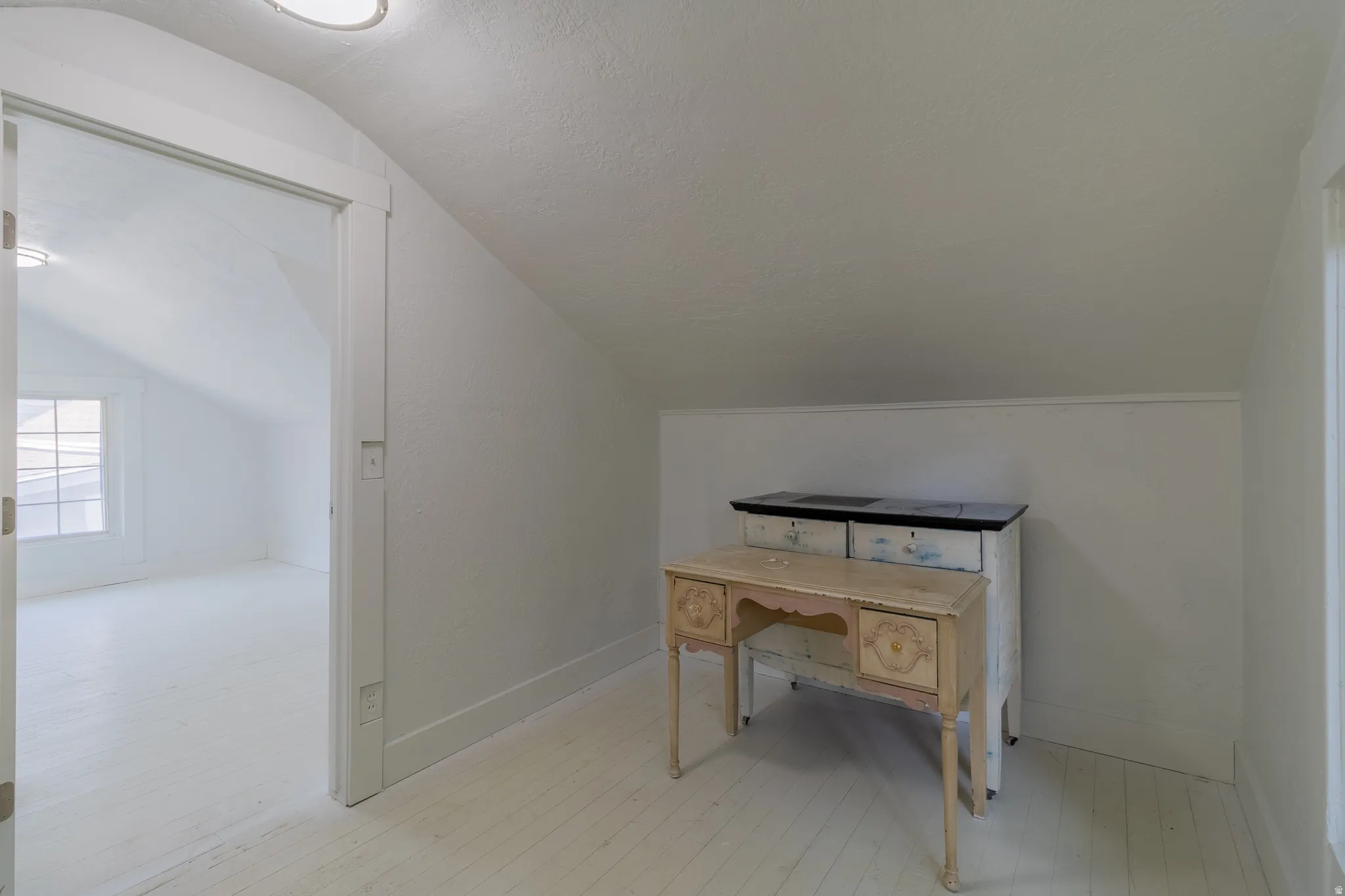 Sloped ceilings with painted wood-finish flooring