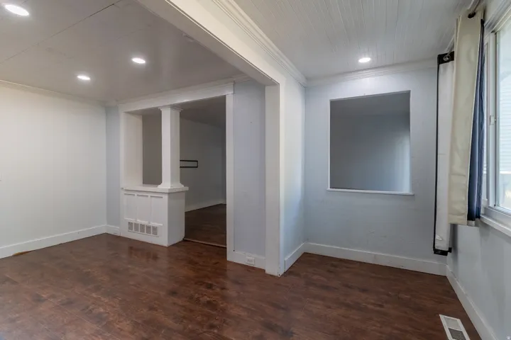 Wood-finish flooring throughout, recessed lighting, and a decorative column feature