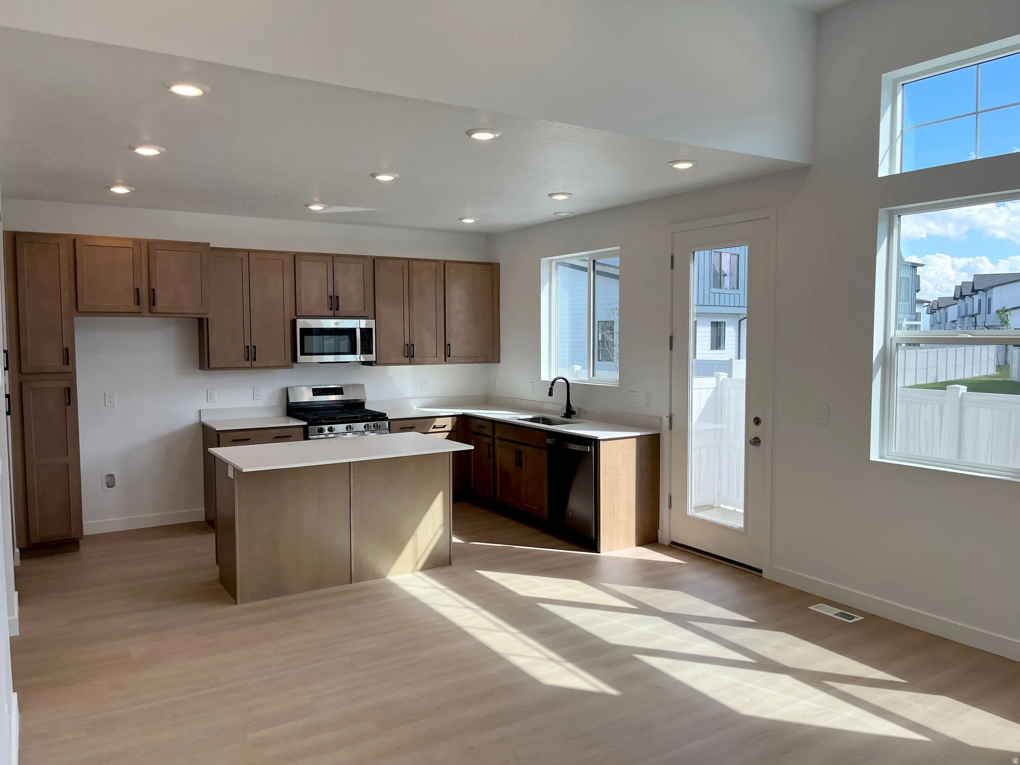 Kitchen featuring wood-finish cabinetry, stainless steel appliances, a center island with countertop, and recessed lighting