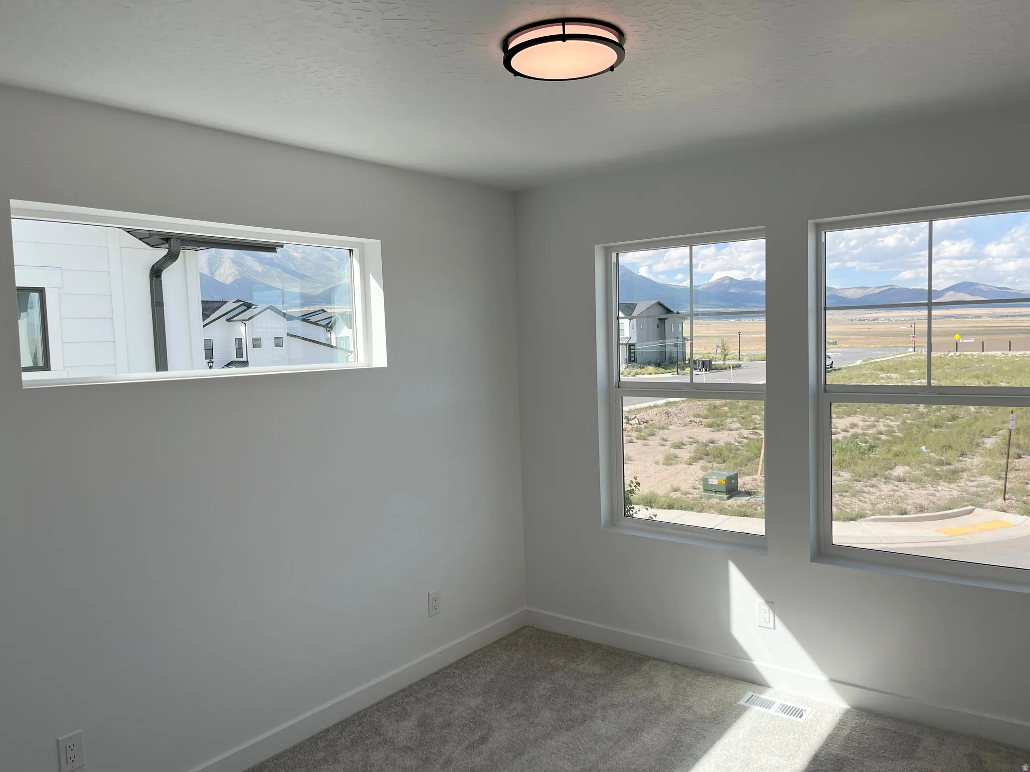 Primary bedroom with large windows and natural light