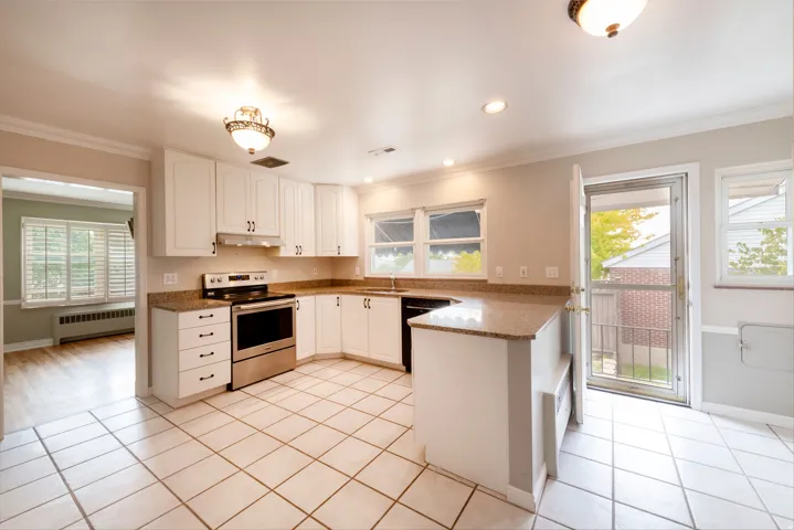 Kitchen featuring white cabinetry, stone countertops, stainless steel appliances, tile flooring, and recessed lighting