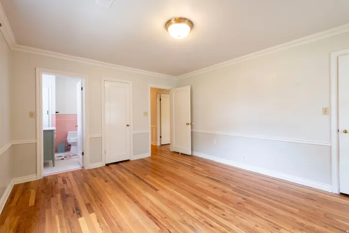 Hardwood flooring, crown molding, chair rail molding, ceiling-mounted light fixture, and white interior doors