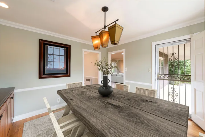 Dining area with crown molding, chair rail molding, and a chandelier with four lanterns