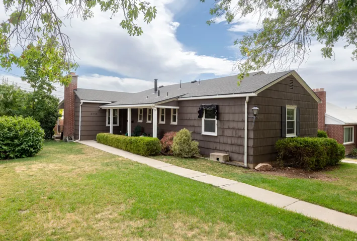 Brown shingle siding, white trim, and a covered porch