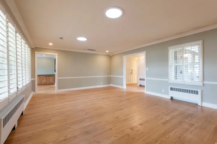 Hardwood flooring throughout, crown molding, chair rail detailing, recessed lighting, and white plantation shutters