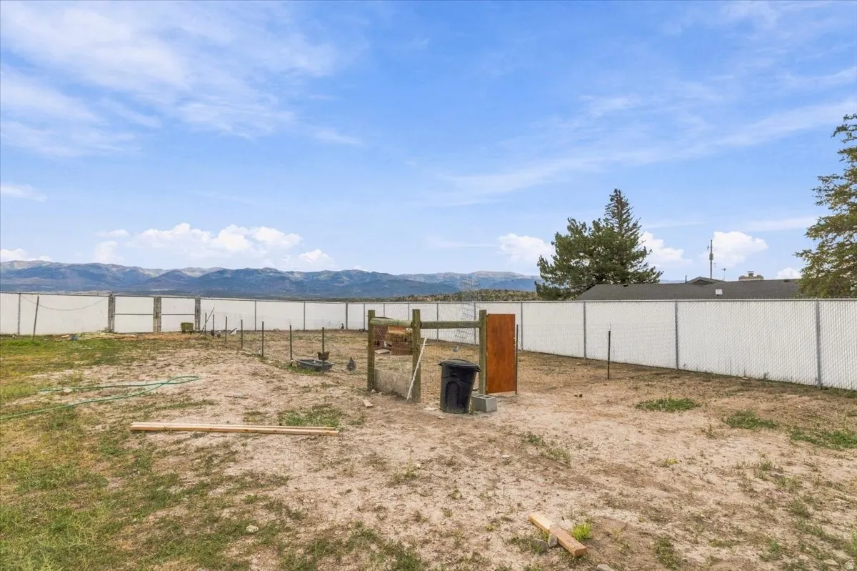 Expansive fenced yard with mountain backdrop