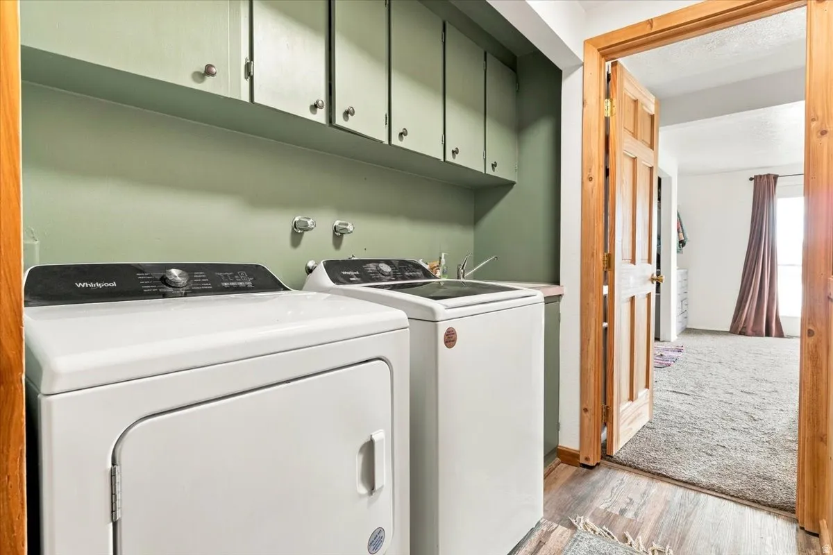 Laundry area featuring wood-finish flooring and built-in cabinetry
