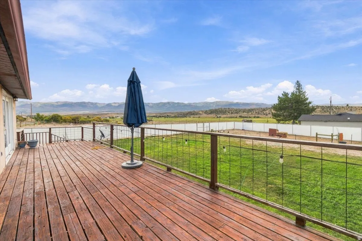 Expansive wood-finish deck with metal and wood railing, providing an outdoor living area
