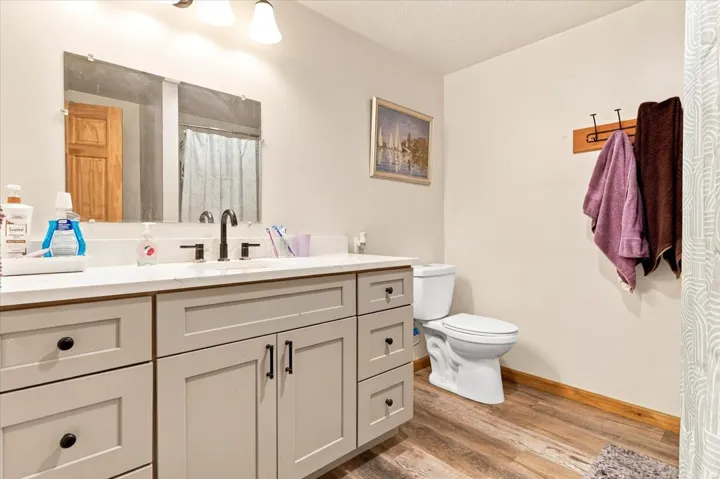 Vanity with light-colored cabinetry, black hardware, and a light-toned countertop