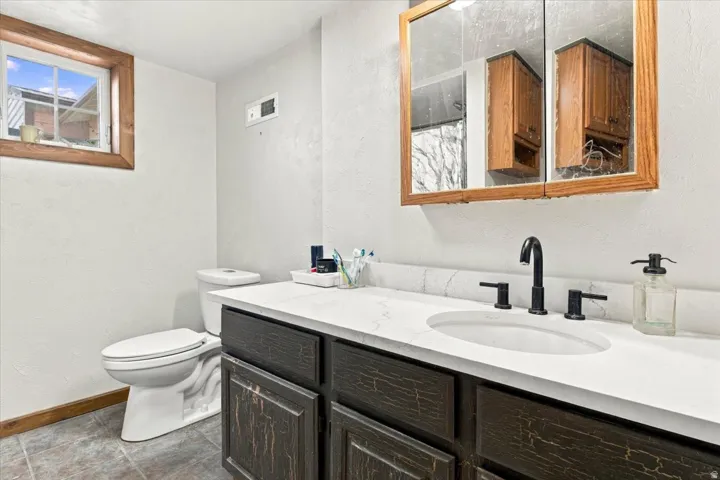 Vanity with white countertop, integrated sink, and matte black faucet