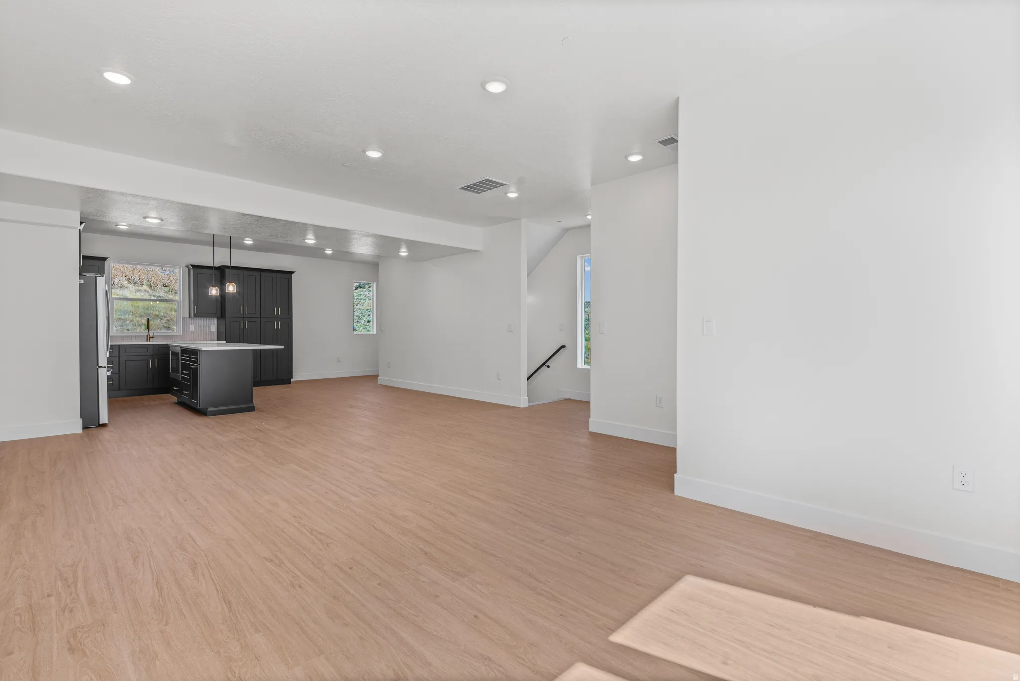 Open concept living area featuring wood-finish flooring