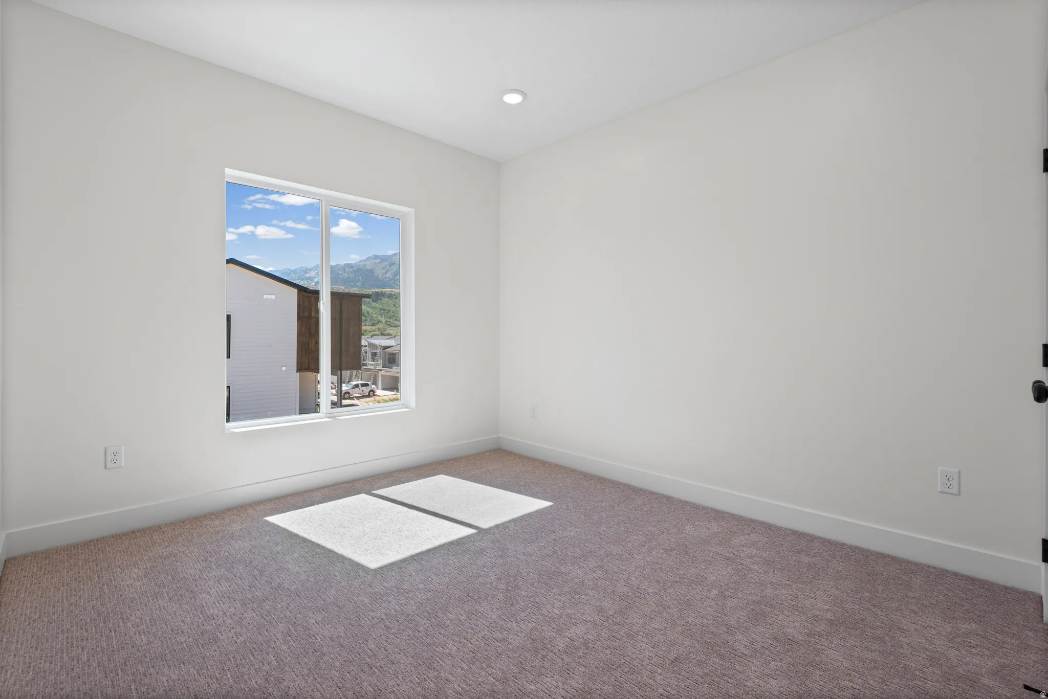 Neutral wall tones, recessed ceiling lighting, and soft pile carpeting