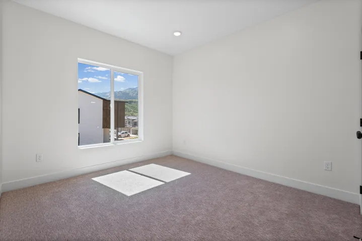 Neutral wall tones, recessed ceiling lighting, and soft pile carpeting