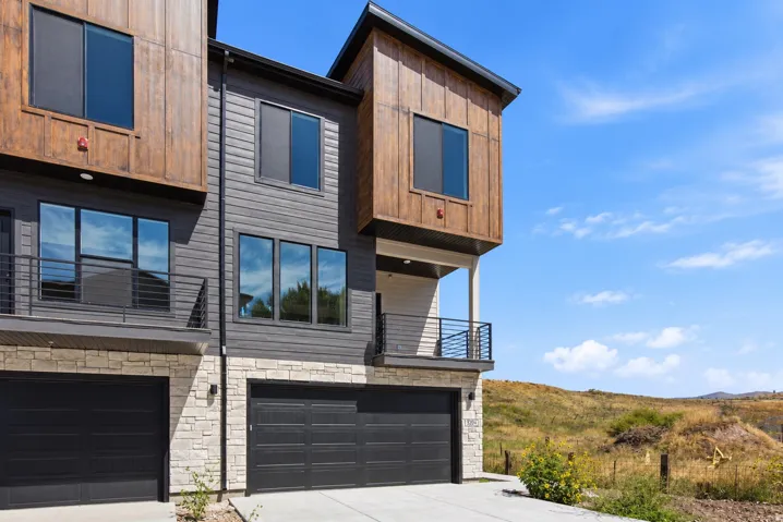 Modern exterior featuring wood-finish siding, dark gray siding, and a stone facade