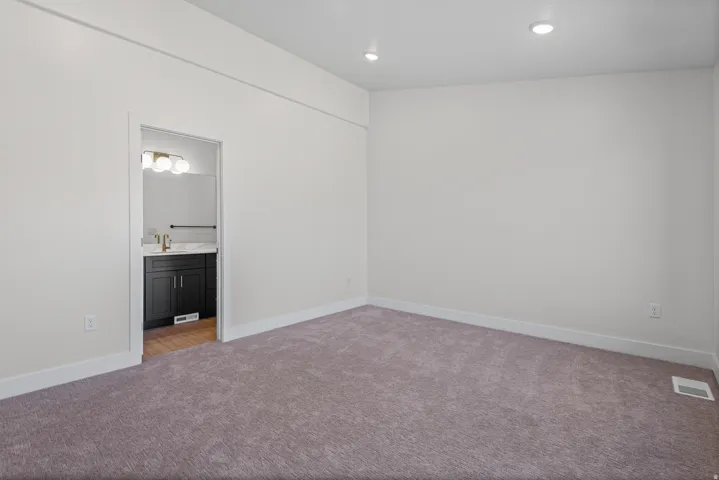 Recessed ceiling lighting, plush carpeting, bright white wall paint, and white trim