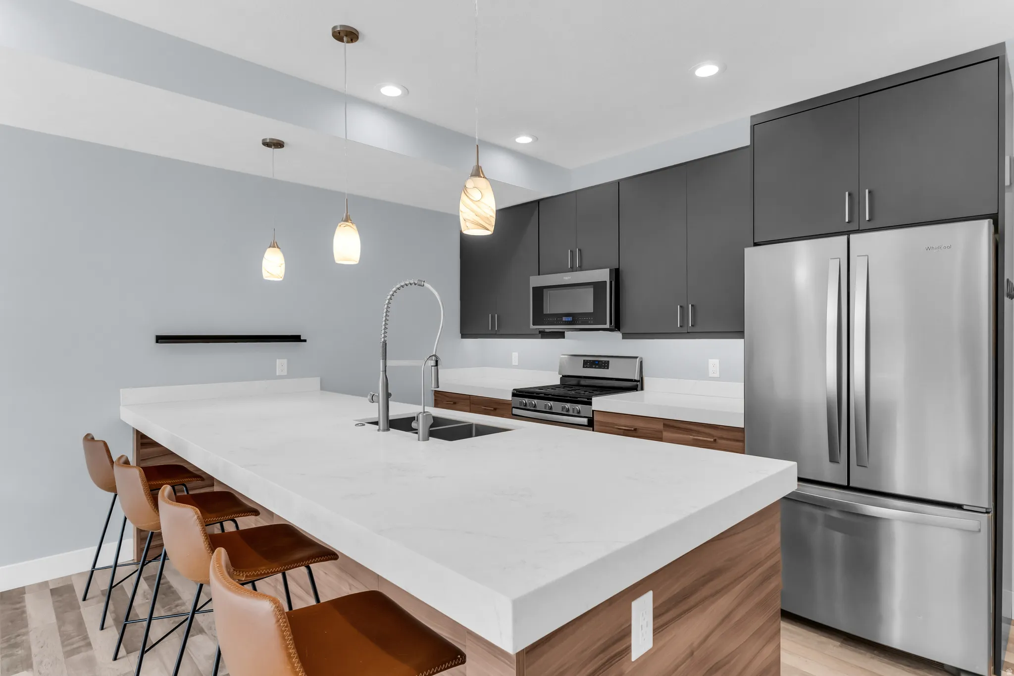 Expansive kitchen island with a light-toned countertop, integrated sink, and gooseneck faucet