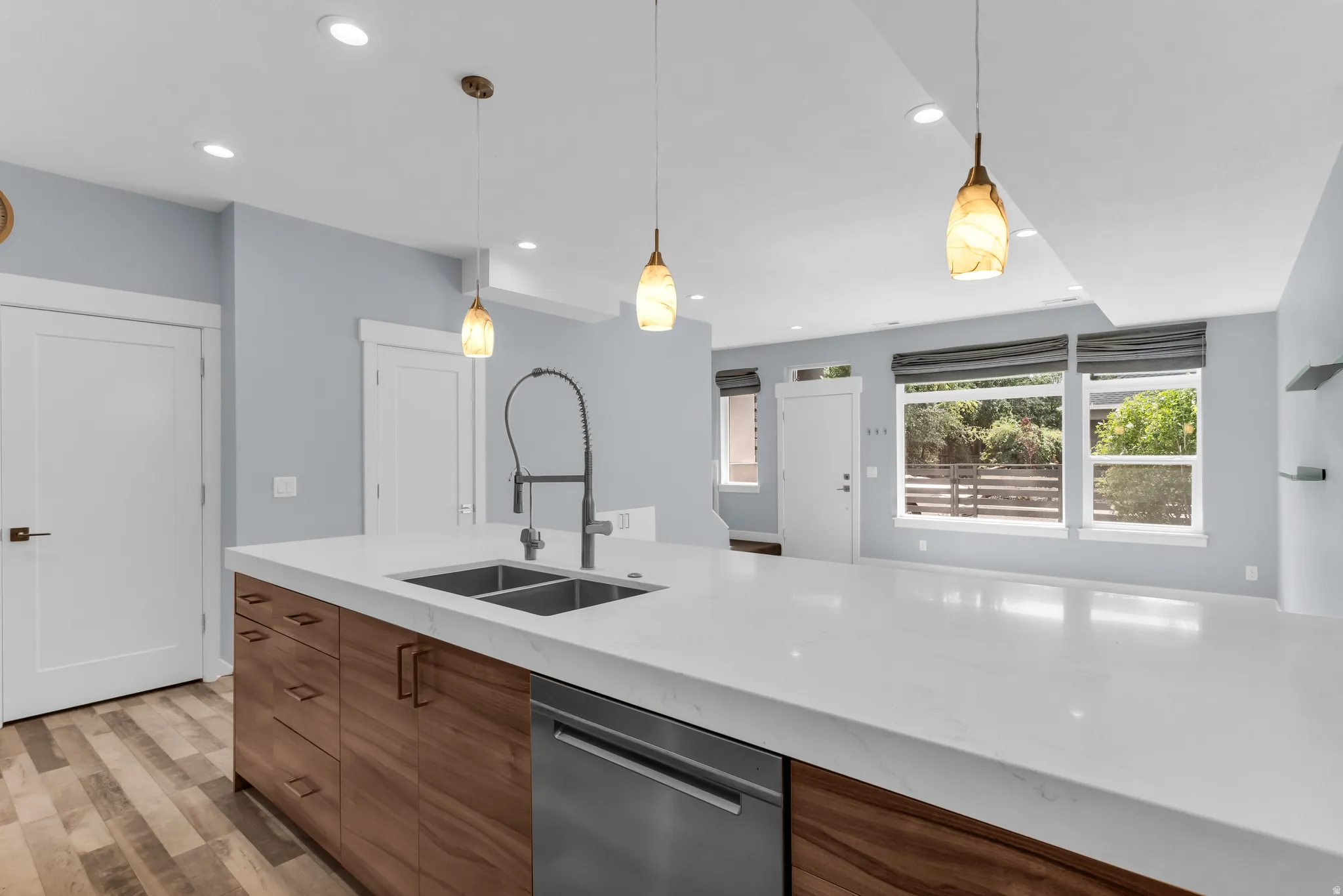 Kitchen island with white countertop, wood-finish cabinetry, and stainless steel appliances