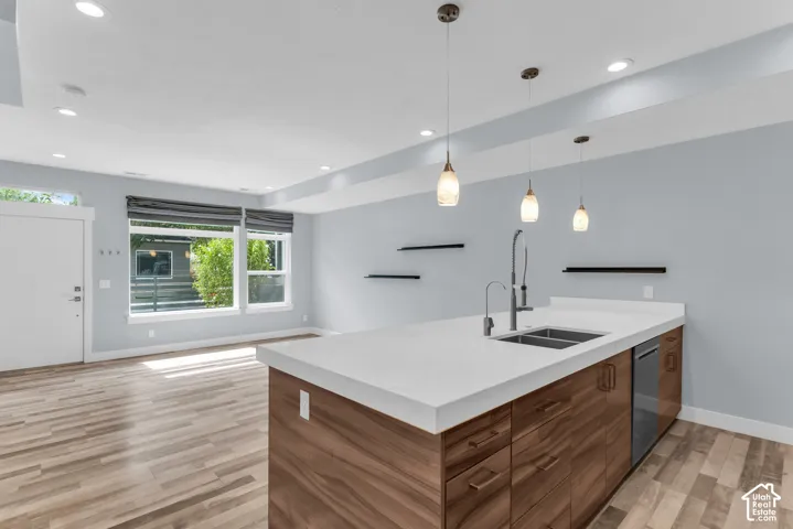 Spacious open-concept living area featuring wood-finish flooring, recessed lighting, and large windows