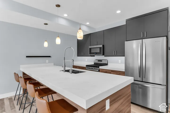 Expansive kitchen island with a light-toned countertop, integrated sink, and gooseneck faucet