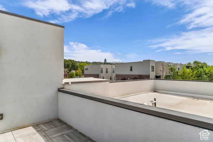Rooftop patio with tiled flooring and low stucco walls