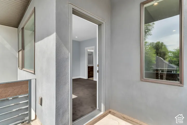 Stucco exterior with multiple windows and a metal railing