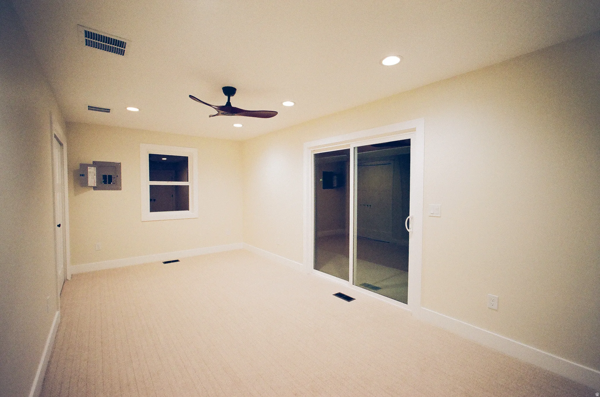 Recessed lighting, ceiling fan, sliding glass door, single window, and neutral carpeting