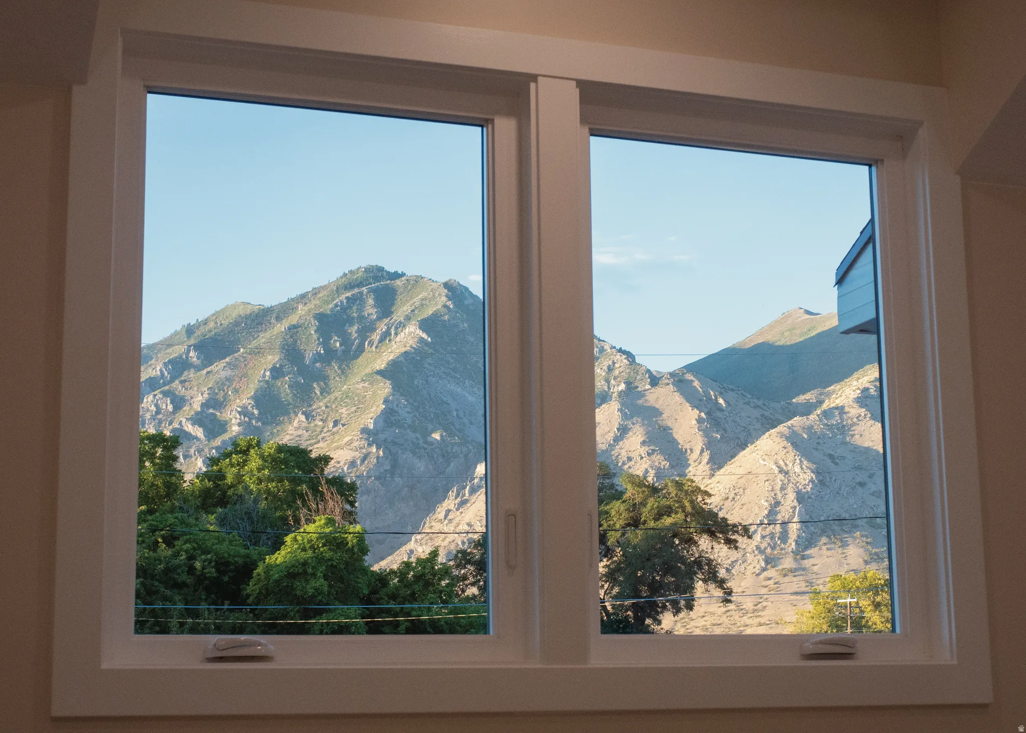 Dual pane window with white trim framing expansive mountain scenery