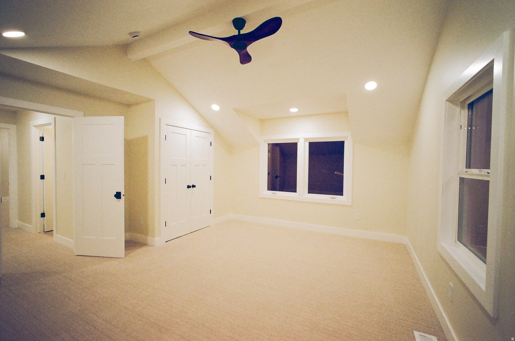 Sloped ceilings with recessed lighting, ceiling fan, carpet flooring, and white trim windows