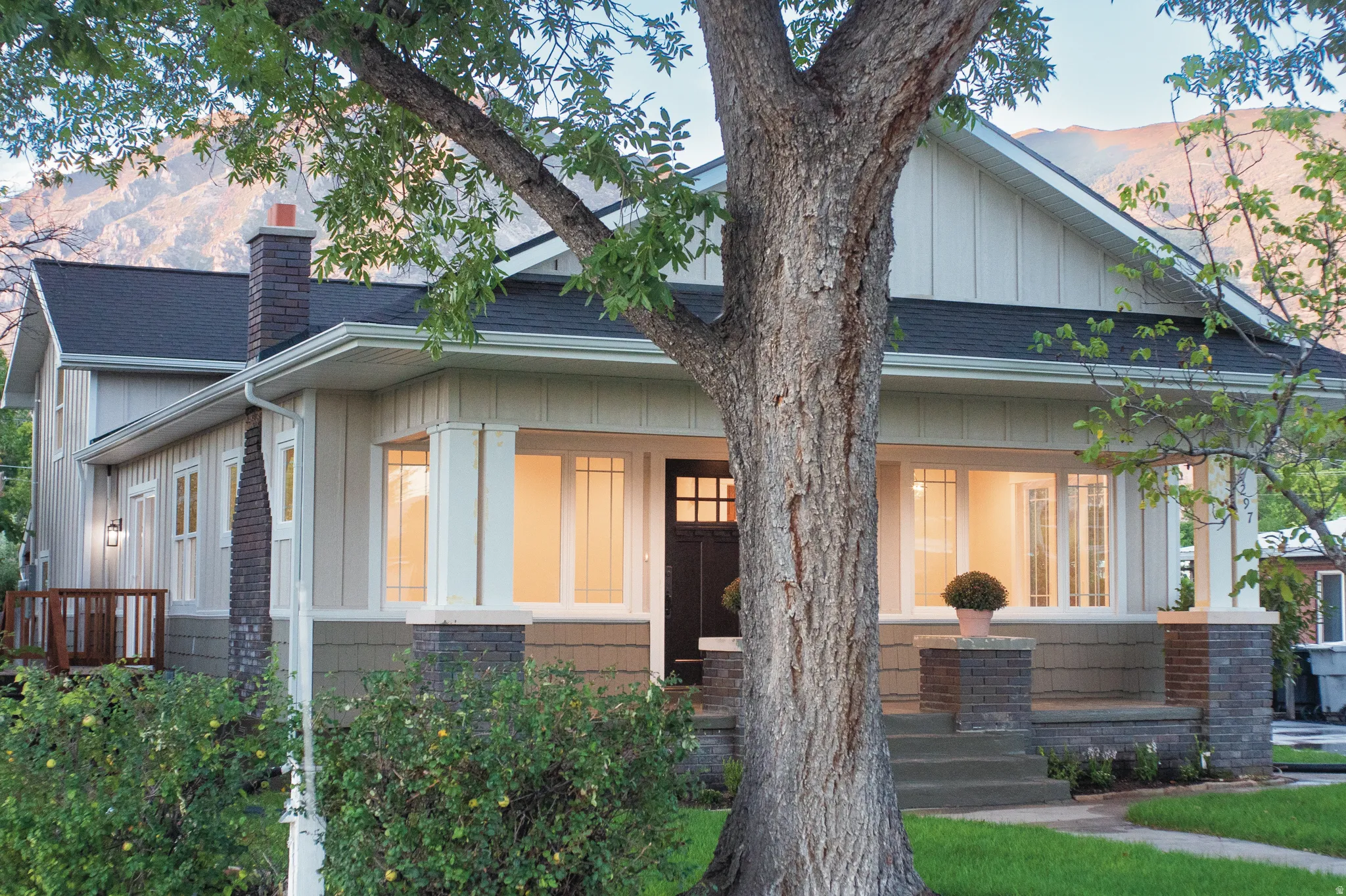 Craftsman-style exterior with a dark-pitched roof and brick chimney
