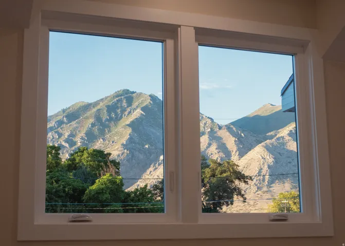 Dual pane window with white trim framing expansive mountain scenery