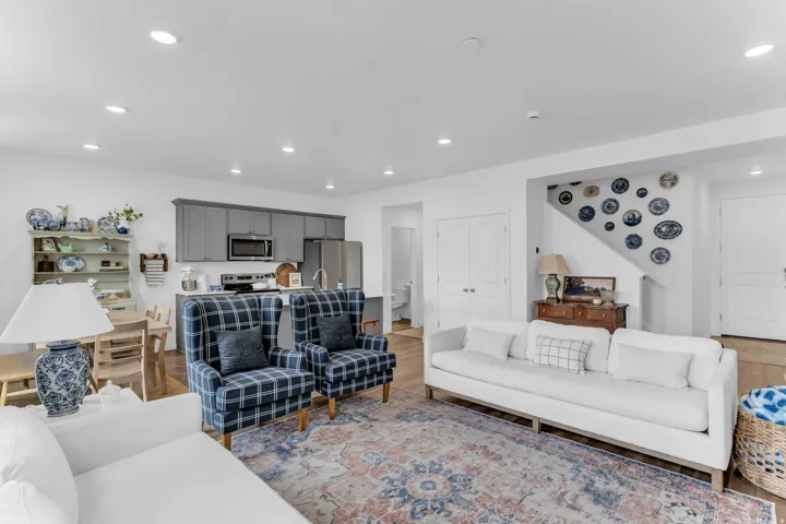 Recessed lighting, wood-finish flooring, gray cabinetry, stainless steel appliances, and white paneled doors
