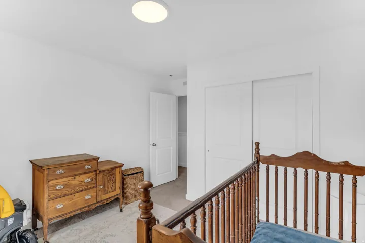 Recessed lighting, white walls, and a light-toned carpet create a bright interior