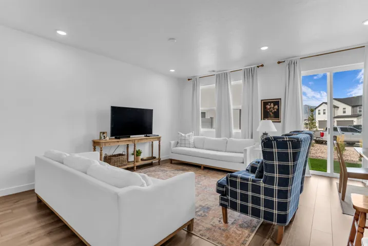 Recessed lighting, wood-finish flooring, white walls, and a sliding glass door