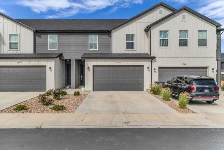 Contemporary multi-family exterior featuring board and batten siding, dark gray horizontal siding, and attached garages with concrete driveways
