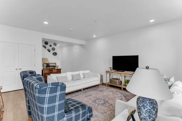 Recessed ceiling lighting, wood-finish flooring, and white walls