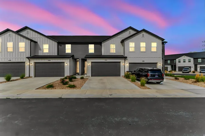 Contemporary townhome exteriors featuring vertical and horizontal siding, integrated single-car garages, and concrete driveways